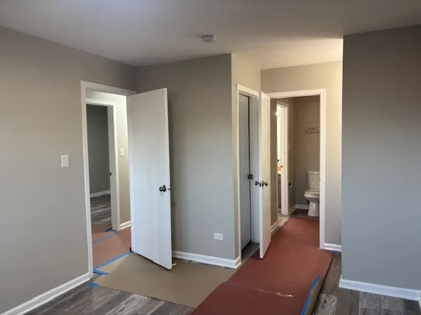 a view of a hallway with wooden floor and closet