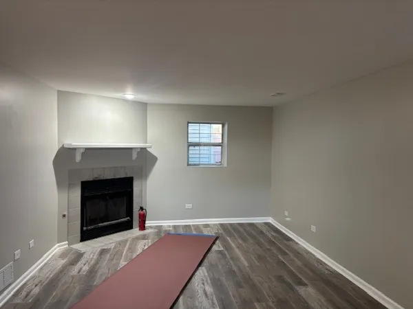 an empty room with windows and fireplace