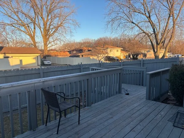 a view of a roof deck with wooden fence and floor
