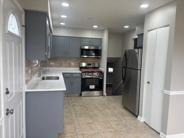 a kitchen with stainless steel appliances granite countertop a refrigerator a sink and a stove