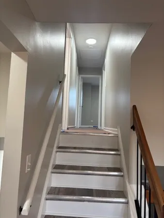 a view of staircase with white walls and railing