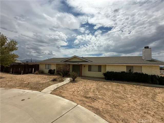 a view of house with yard and car parked