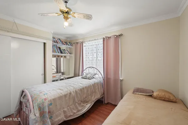a view of a hallway with wooden floor and living room