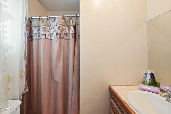 a bathroom with a toilet a sink and shower curtain