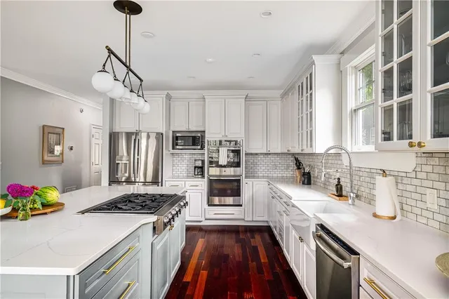a kitchen with granite countertop a sink stove and refrigerator