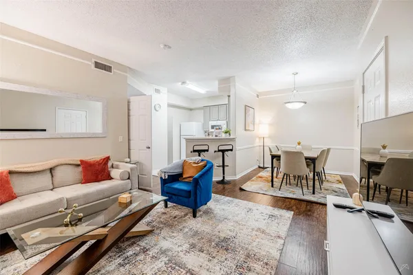 a living room with furniture and a dining table with kitchen view