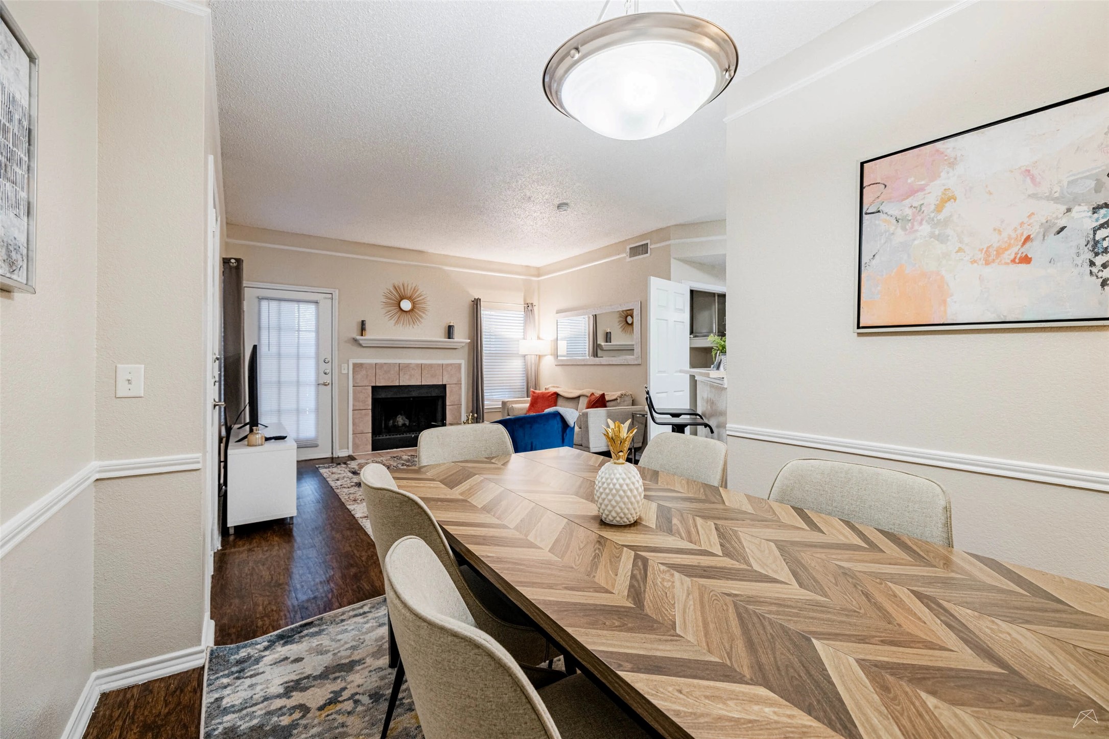 11908 Anderson Mill Road, Unit 312 Cedar Park, TX 78613 - Photo 18 of 25 a view of a dining room with furniture a fireplace and wooden floor