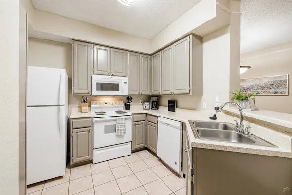 a kitchen with appliances a sink and cabinets