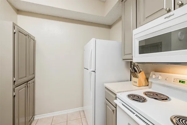 a kitchen with a refrigerator and stove top oven