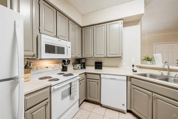 a kitchen with appliances a sink and cabinets