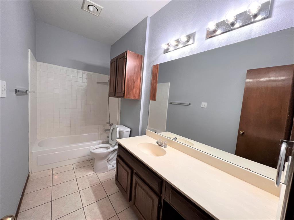 738 Ridgemont Drive Allen, TX 75002 - Photo 5 of 21 Bathroom featuring a full-width vanity with an integrated sink and laminate countertop, a large mirror, and two multi-bulb light fixtures