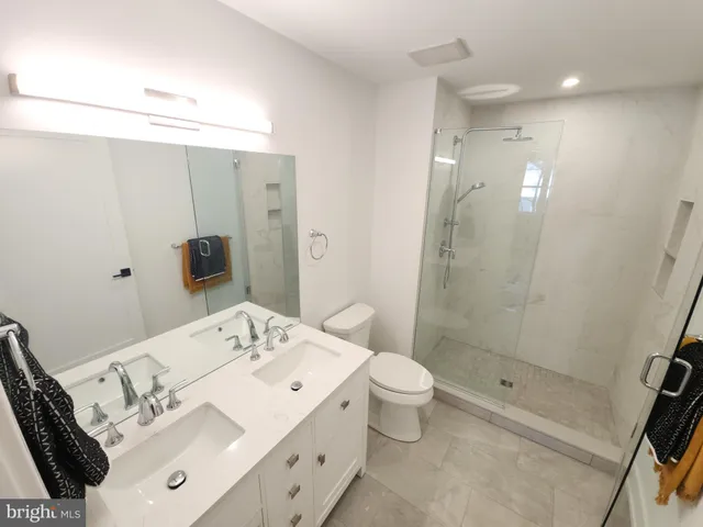 a bathroom with a bathtub shower sink vanity and toilet
