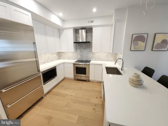 a kitchen with kitchen island stainless steel appliances a stove sink and microwave