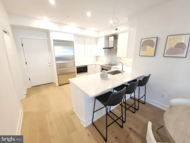 a kitchen with a table chairs refrigerator and cabinets