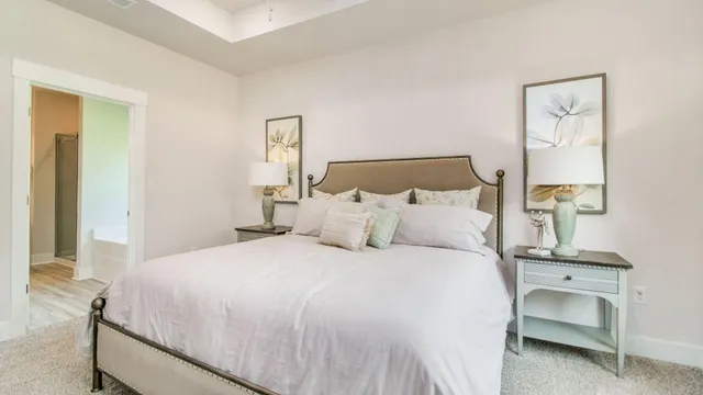 a bedroom with a bed a large mirror and a large window