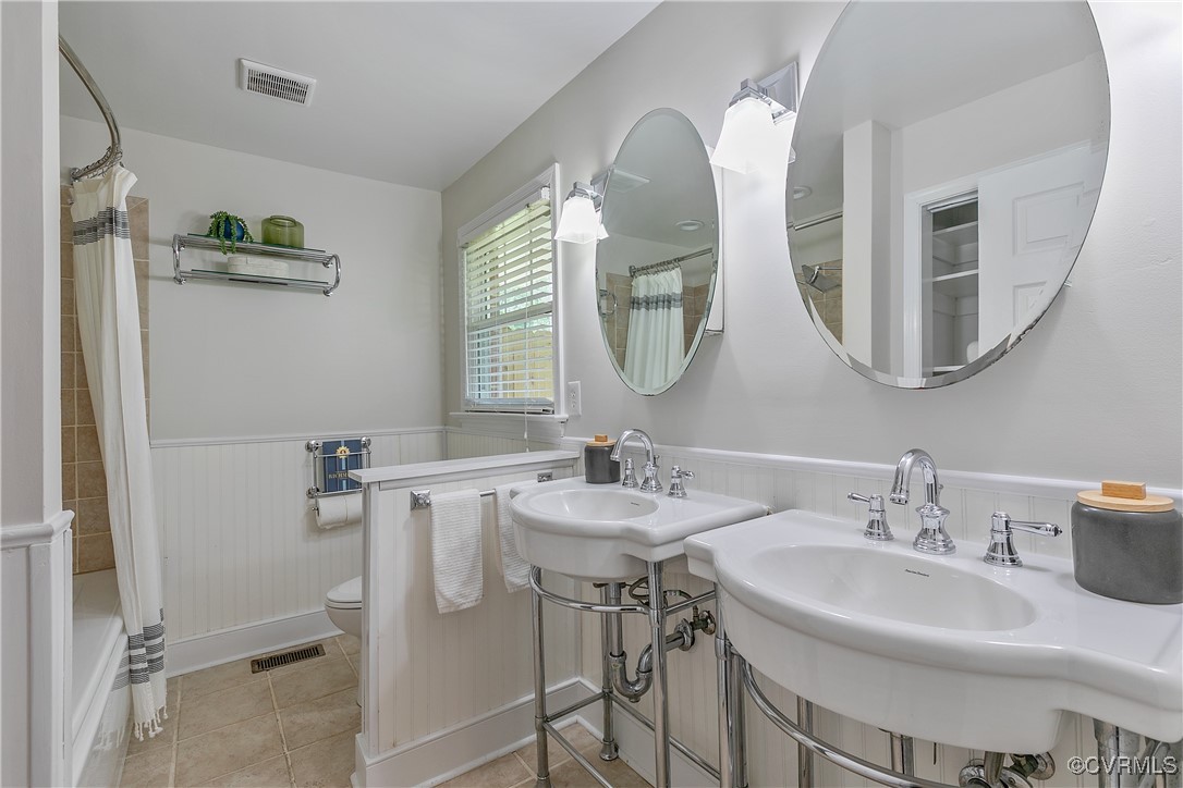7660 Cherokee Road Richmond, VA 23225 - Photo 24 of 36 a bathroom with a double vanity sink and a mirror