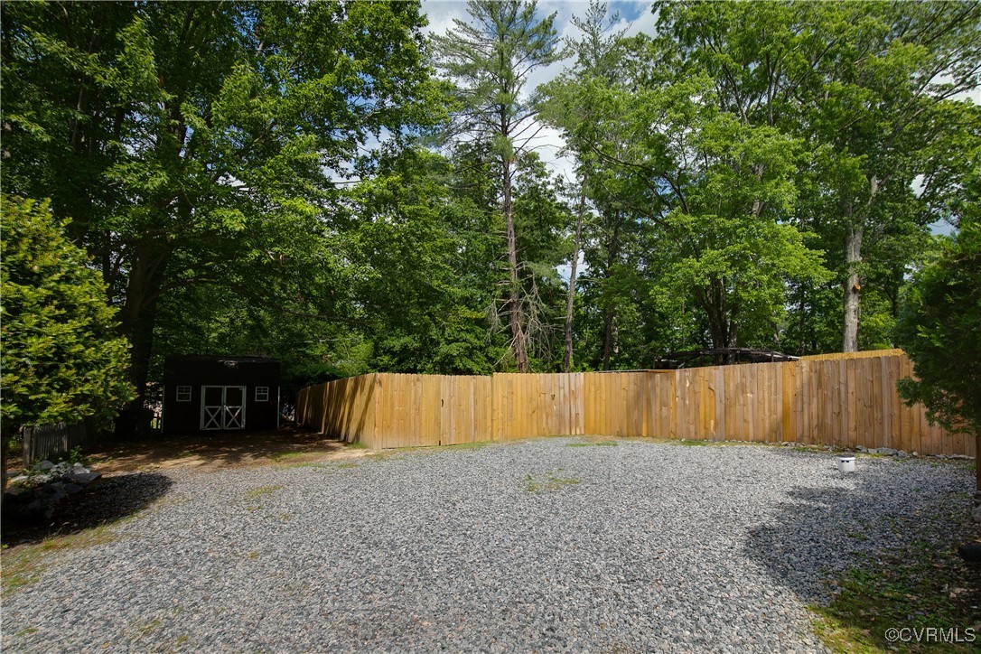 7660 Cherokee Road Richmond, VA 23225 - Photo 35 of 36 a view of backyard with large trees and wooden fence