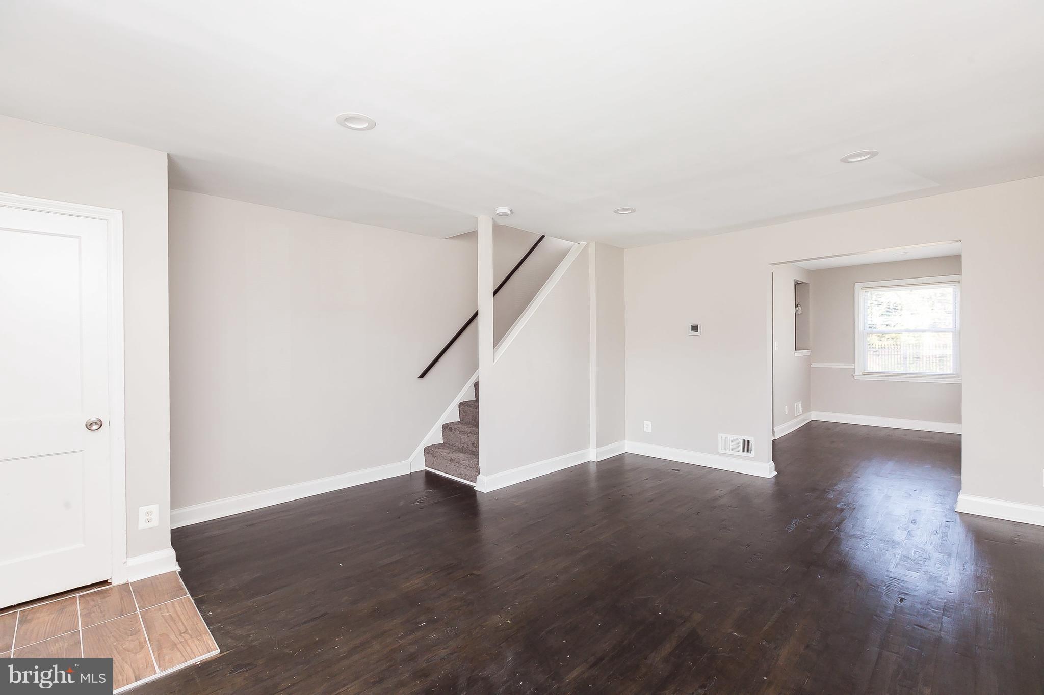 960 Middlesex Road Essex, MD 21221 - Photo 6 of 29 a view of an empty room with wooden floor and stairs