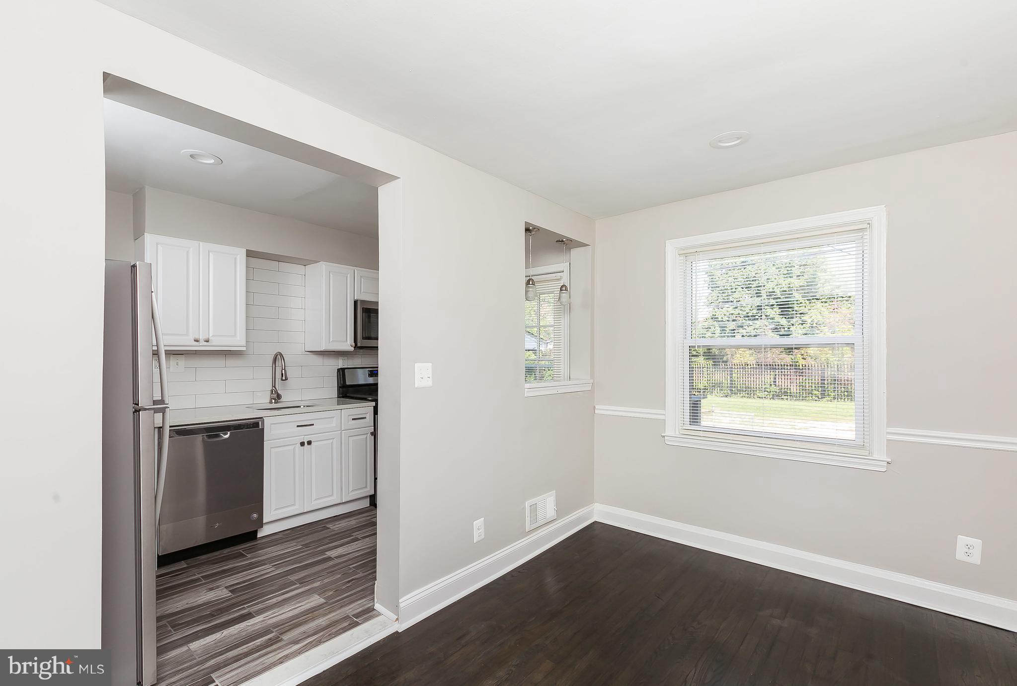 960 Middlesex Road Essex, MD 21221 - Photo 9 of 29 a view of a kitchen with wooden floor electronic appliances and windows