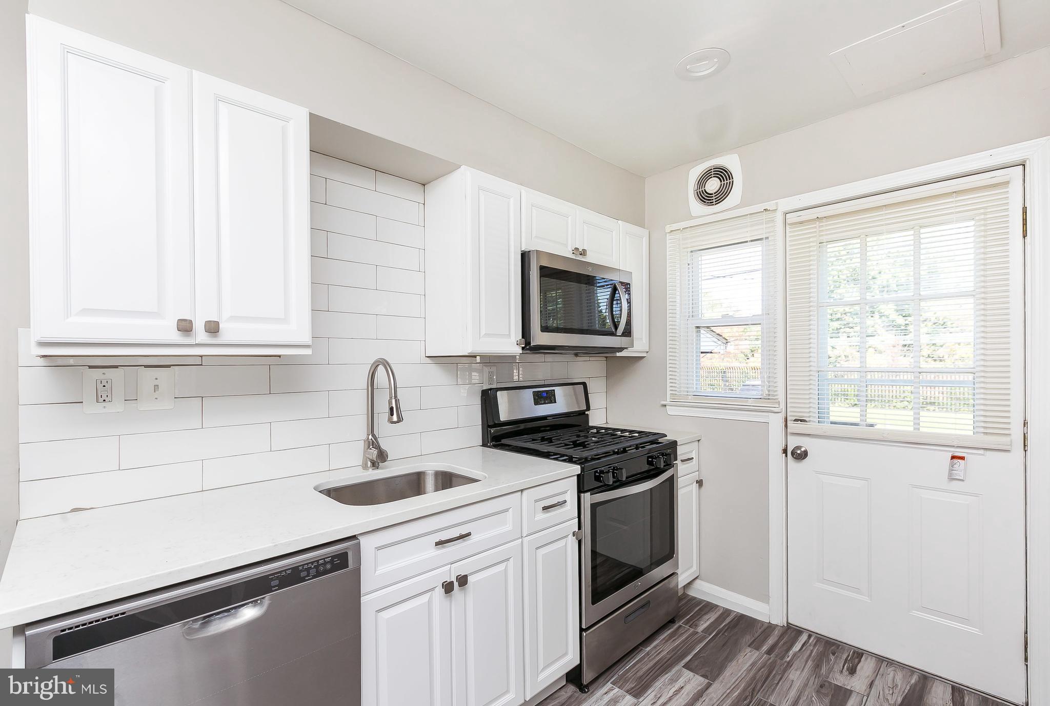 960 Middlesex Road Essex, MD 21221 - Photo 10 of 29 a kitchen with white cabinets stainless steel appliances and sink