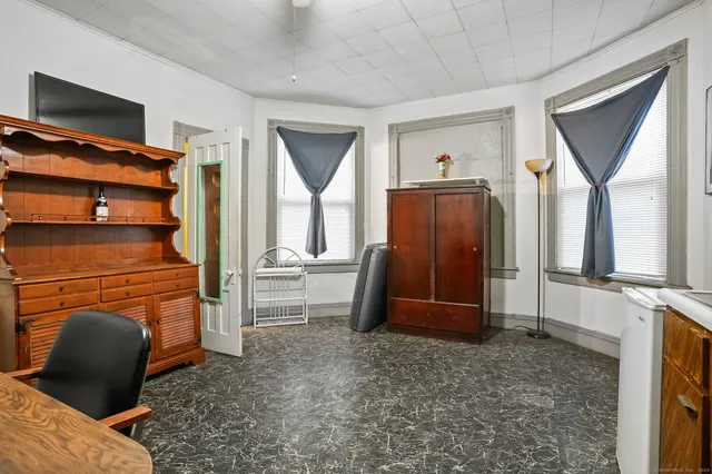 a living room with furniture a flat screen tv and a window
