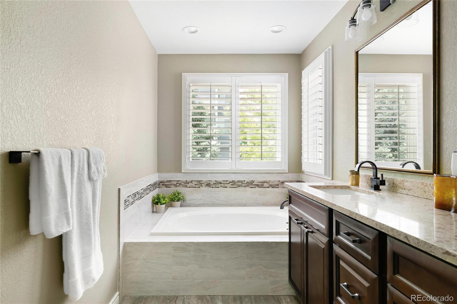 10523 West Peakview Place Littleton, CO 80127 - Photo 26 of 40 a bathroom with a tub sink and a window