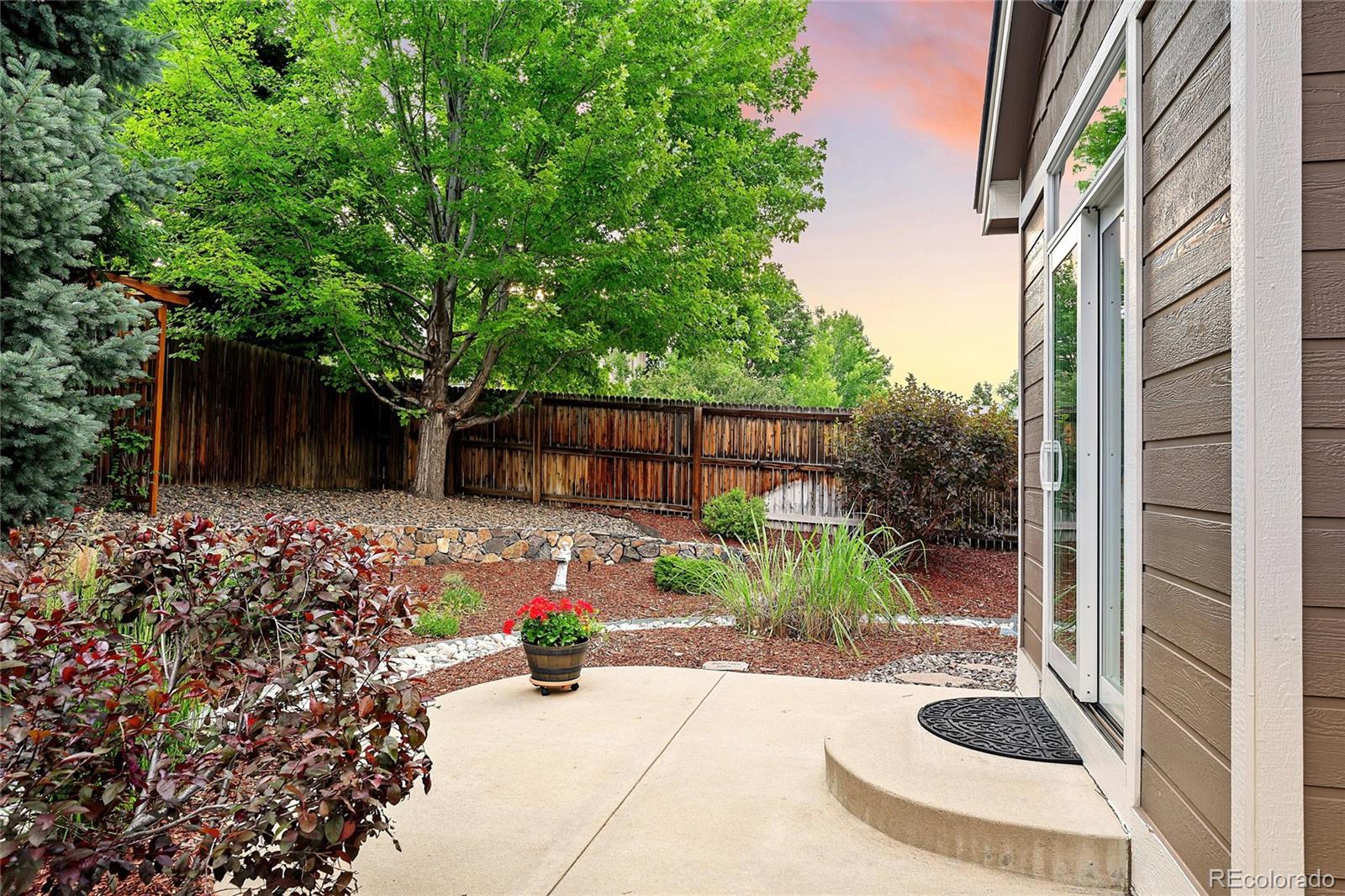10523 West Peakview Place Littleton, CO 80127 - Photo 32 of 40 a view of a backyard with plants and brick wall