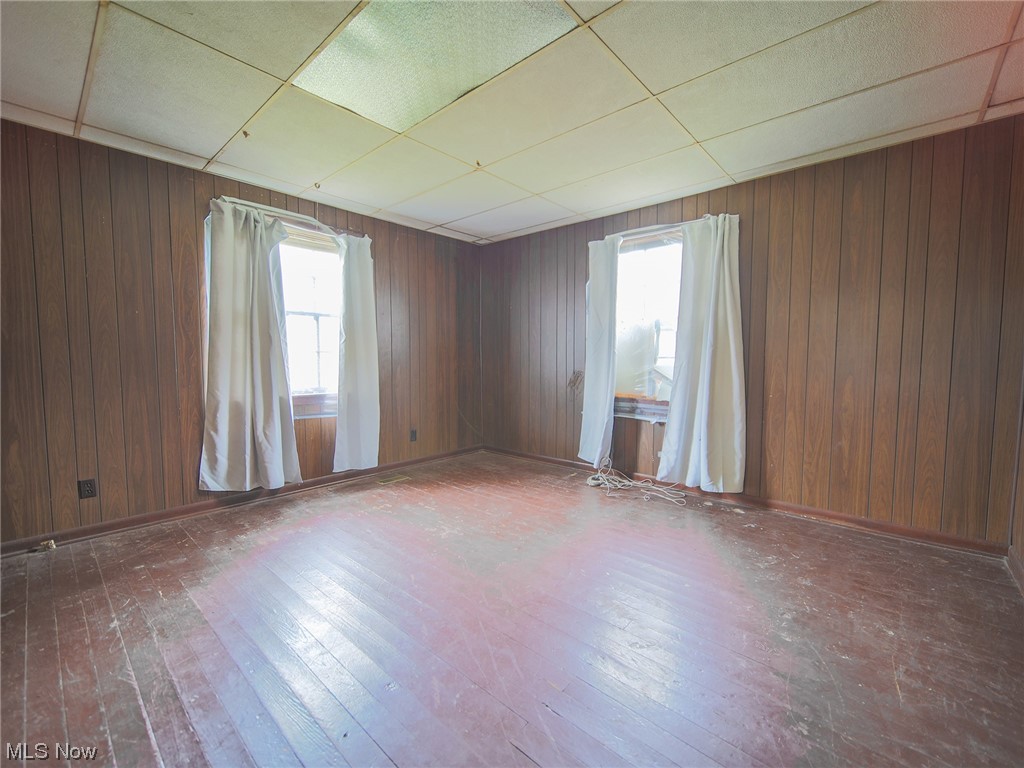 12432 Glasgow Road Southwest Port Washington, OH 43837 - Photo 12 of 31 Unfurnished room with plenty of natural light, dark hardwood / wood-style floors, and a drop ceiling