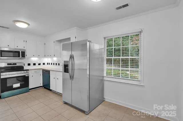 a kitchen with stainless steel appliances granite countertop a refrigerator sink and stove