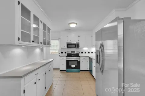 a kitchen with stainless steel appliances granite countertop a refrigerator and a stove top oven