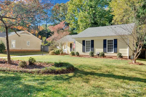 a view of a house with backyard and trees