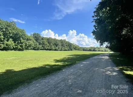 a view of a lake with a yard and large trees