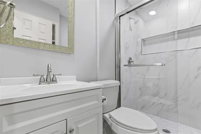 a bathroom with a sink a toilet and shower