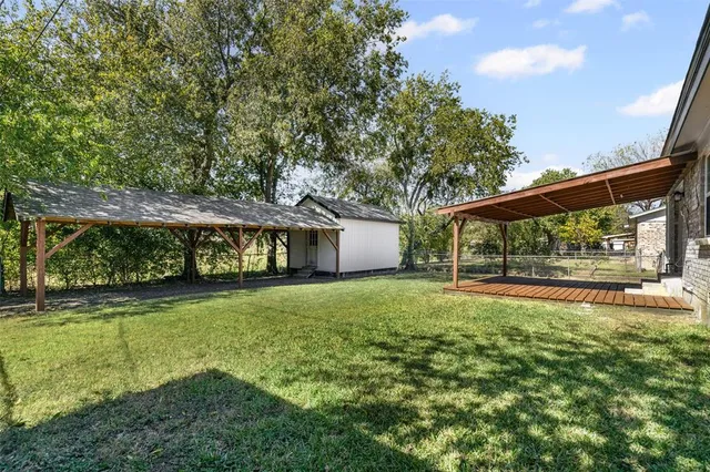 a view of a house with backyard and sitting area