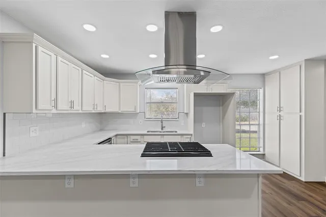 a kitchen with a stove and white cabinets