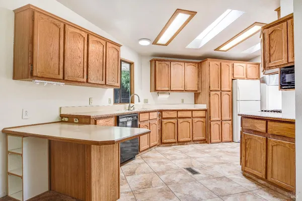 a kitchen with stainless steel appliances granite countertop a refrigerator sink stove and white cabinets