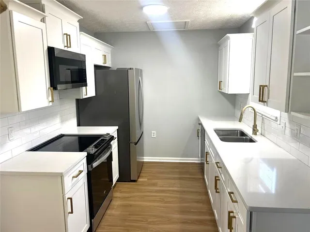a kitchen with stainless steel appliances granite countertop a sink stove and refrigerator
