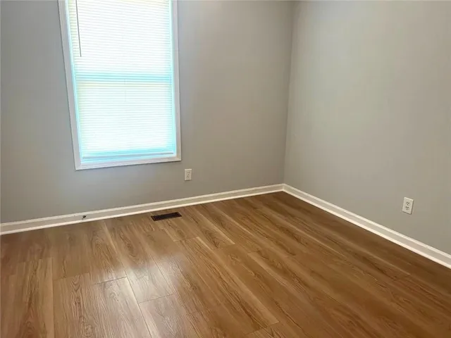 an empty room with wooden floor and door