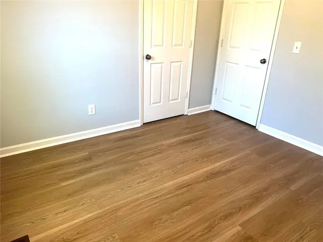 a view of a room with wooden floor and window