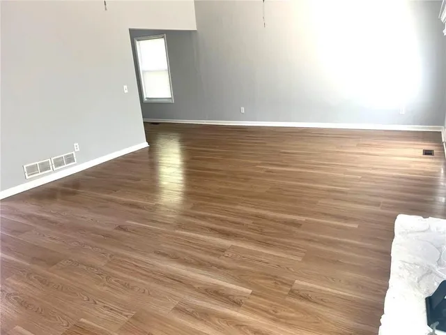a view of room with window and wooden floor