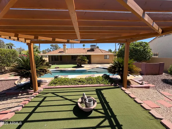 a view of a patio with table and chairs potted plants and floor to ceiling window