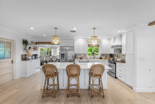 a kitchen with granite countertop stainless steel appliances a dining table and chairs