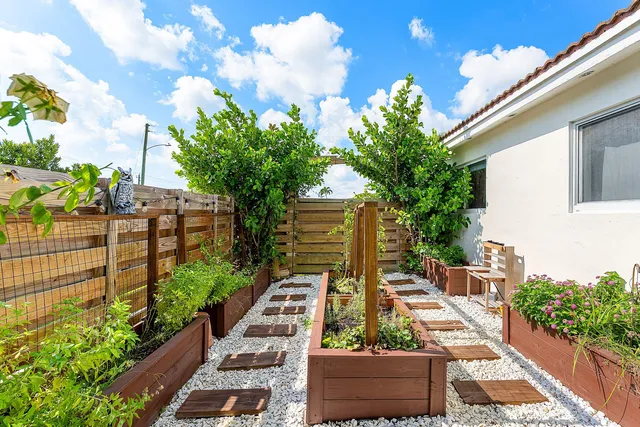 a aerial view of a house with a yard and potted plants