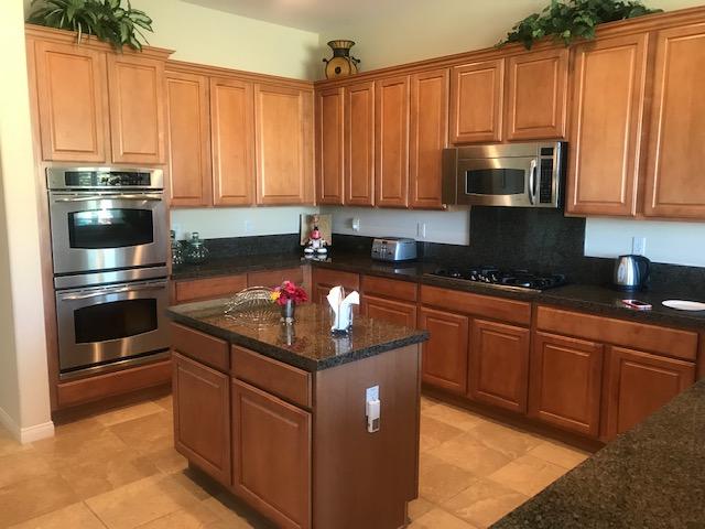 81194 Avenida Sombra Indio, CA 92203 - Photo 6 of 24 a kitchen with kitchen island granite countertop a sink stainless steel appliances and cabinets