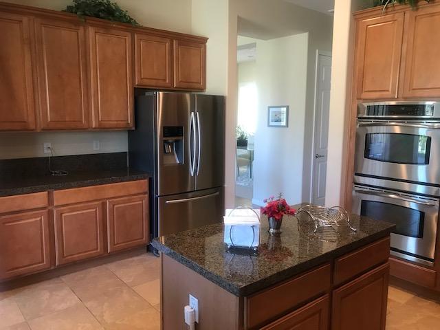 81194 Avenida Sombra Indio, CA 92203 - Photo 7 of 24 a kitchen with stainless steel appliances granite countertop a refrigerator and a stove