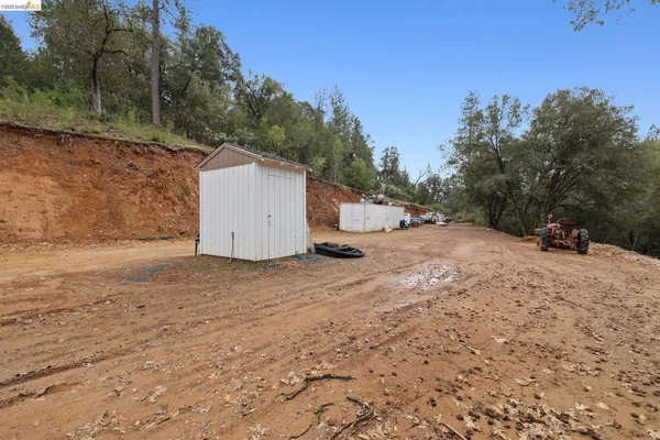 a dirt road with trees in the background
