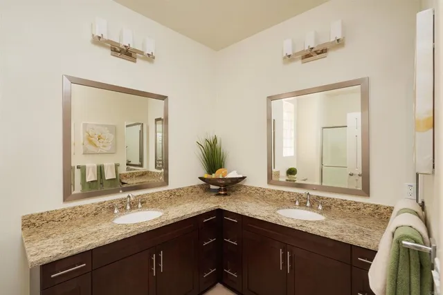 a bathroom with a granite countertop sink double and mirror