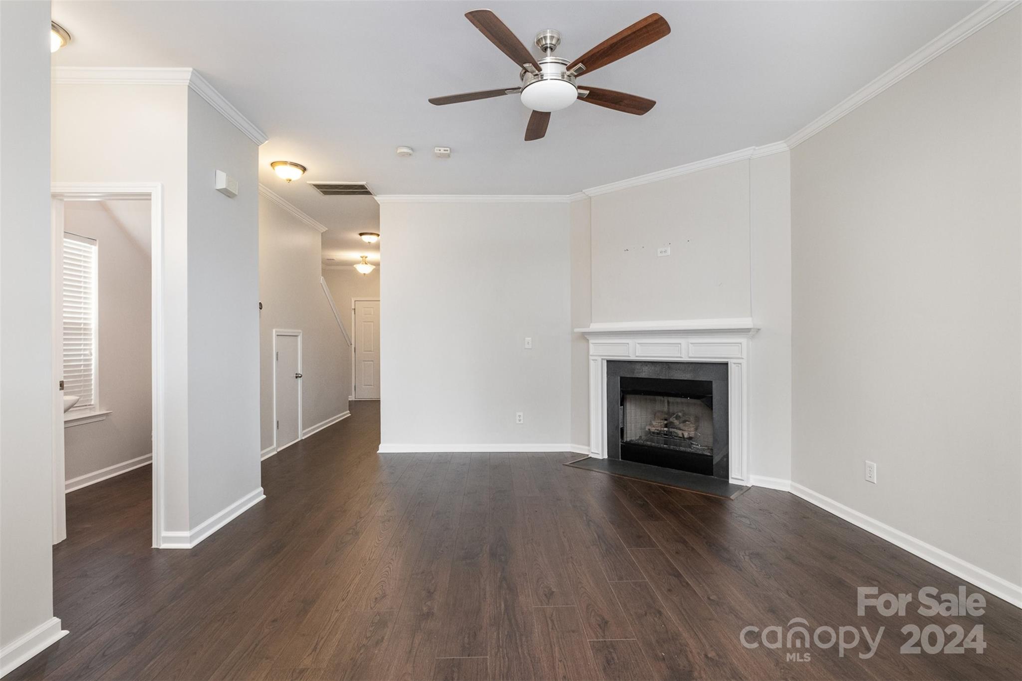 2149 Midnight Blue Lane Fort Mill, SC 29708 - Photo 5 of 30 an empty room with wooden floor a ceiling fan and a fireplace