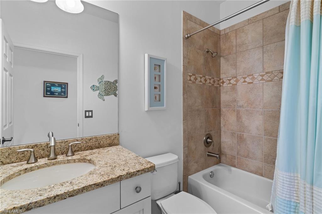6693 Alden Woods Circle, Unit 202 Naples, FL 34113 - Photo 16 of 25 a bathroom with a granite countertop sink a toilet and shower