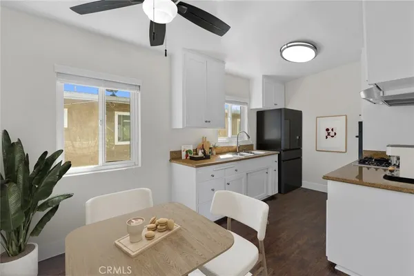 a kitchen with sink refrigerator dining table and chairs